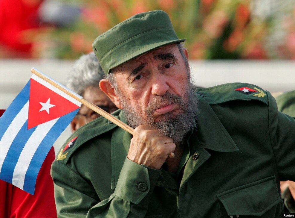 Holding a Cuban flag, Castro listens to a speaker during the May Day parade in Havana's Revolution Square in 2005.