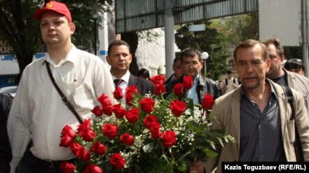 Российский оппозиционный политик Александр Батов (слева) и правозащитник Лев Пономарев идут возлагать цветы к памятнику Абаю. Алматы, 19 мая 2012 года.