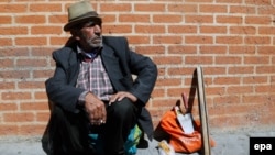 An Iranian laborer sits next to his tools on a Tehran street in April. Despite the nuclear deal, the recovery of an economy deeply affected by sanctions and years of mismanagement will take some time.