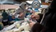 A woman counts out several tenge banknotes while purchasing some dairy products at a market in Almaty. The declining value of the Kazakh currency has hit the country's economy hard and some believe the worst is yet to come. 