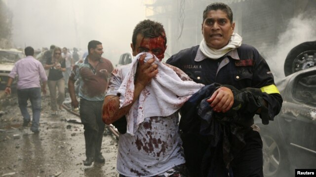 A Lebanese civil defence member helps a wounded man at the site of an explosion in Ashrafieh, central Beirut, on October 19. 