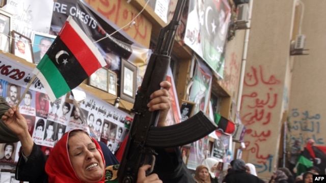 A woman fires a weapon in the air as people gather to celebrate the UN resolution in the eastern rebel-held city of Benghazi today.