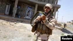 A Kurdish Peshmerga fighter takes part in a sweep of the Bakirta village near the town of Makhmur, south of Irbil, the capital of Iraqi Kurdistan, on August 27.