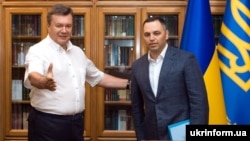 Ukrainian ex-President Viktor Yanukovych (left) and aide Andriy Portnov talk in Crimea in August 2010.