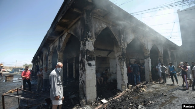 People gather at the site of a suicide attack at the entrance of the Shi'ite Mausoleum of Sayid Muhammad bin Ali al-Hadi in Balad, north of Baghdad, on July 8.