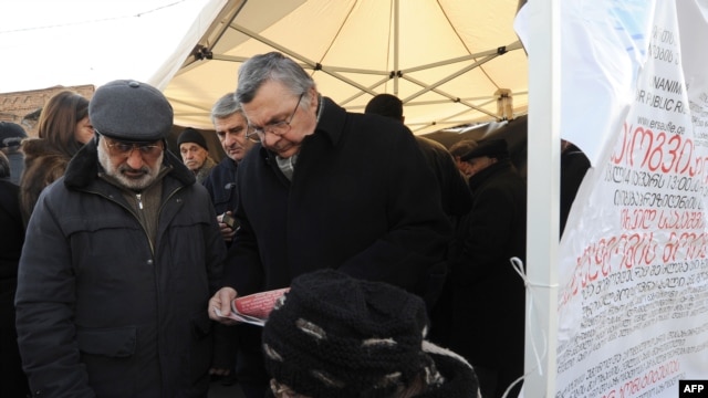 Georgian opposition supporters collect signatures for a petition asking for the resignation of President Mikheil Saakashvili near his office in central Tbilisi on January 4.