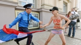 Путинге қарсы акцияға шыққан Femen ұйымының мүшесін полиция ұстап тұр. Киев, 18 шілде 2013 жыл