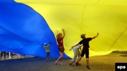 Ukrainian children under a giant national flag in Kyiv in August 2010.