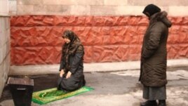 Алмалы аудандық сотының ауласында намаз оқып жатқан әйел. Алматы, 28 желтоқсан 2010 жыл. (Көрнекі сурет)