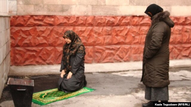 Алмалы аудандық сотының ауласында намаз оқып жатқан әйел. Алматы, 28 желтоқсан 2010 жыл. (Көрнекі сурет)