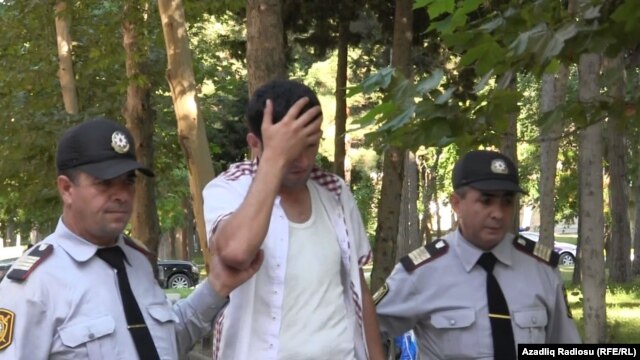 One of those who fell ill after the generator fire at the Bina Shopping Center is escorted away by police.