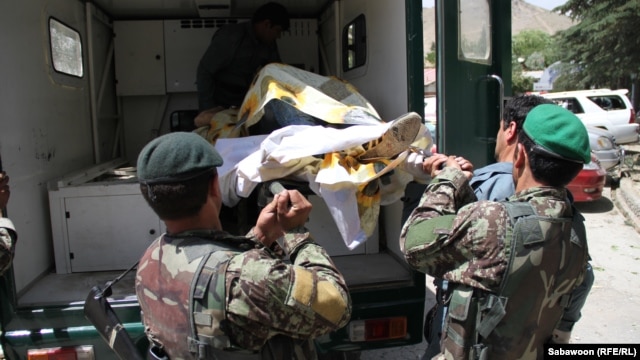 Afghan security forces retrieve one of the casualties from the attack and overnight siege at the popular Qargha Lake recreation area near Kabul that reportedly killed at least 20 people.