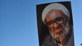 Iranians hold portraits of Iranian cleric Grand Ayatollah Hossein Ali Montazeri during his funeral procession in the holy city of Qom, 21Dec2009