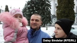 Ihor, 51, reporting for army training in Lviv with his 2-year-old daughter, Bozhenka, and his 14-year-old son, Nazar.