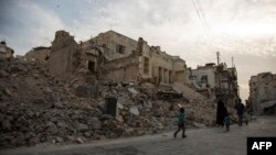 A Syrian family walks past destroyed buildings in the northern city of Aleppo on May 2.