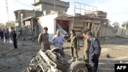 Residents look at the remains of several car bombs that exploded in the northern Iraqi city of Kirkuk on November 14.