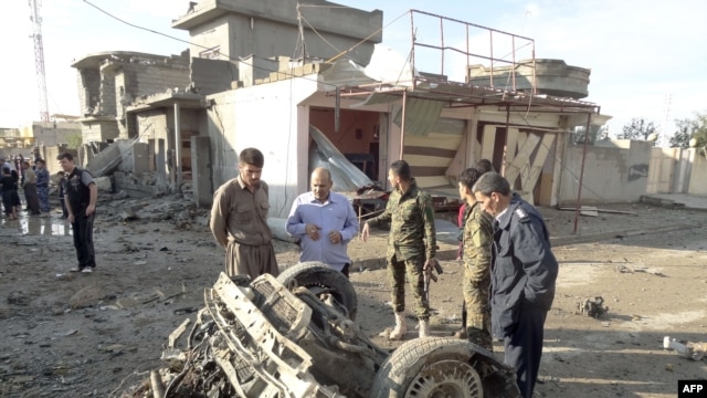 Residents look at the remains of several car bombs that exploded in the northern Iraqi city of Kirkuk on November 14.