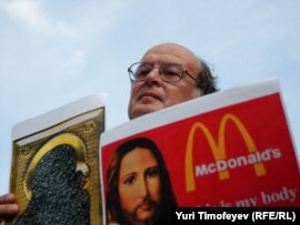 Yury Samodurov holds replicas of some of the exhibited works on July 9.