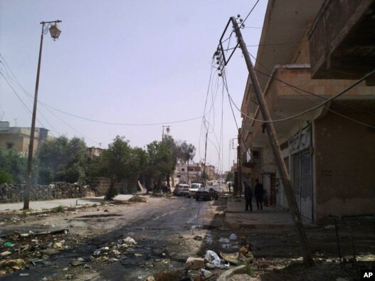 People walk a street strewn with debris in the southern city of Daraa.