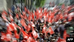 People hold union flags during a demonstration to protest government austerity cuts in Madrid today.