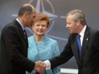 Slovenian Prime Minister Janez Jansa (left) shakes hands with De Hoop Scheffer as Latvian President Vaira Vīķe-Freiberga watches (NATO)