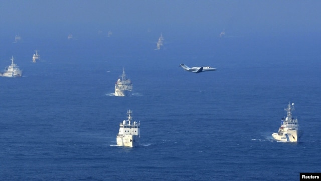 Chinese ocean surveillance, fishery patrol ships, and a Japan Coast Guard patrol ship (right) all sail about 15 kilometers west of the disputed islands, in the East China Sea, on September 18.