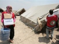 Iraqi Red Crescent workers deliver supplies to a displaced-persons camp in Diyala Governorate (AFP)