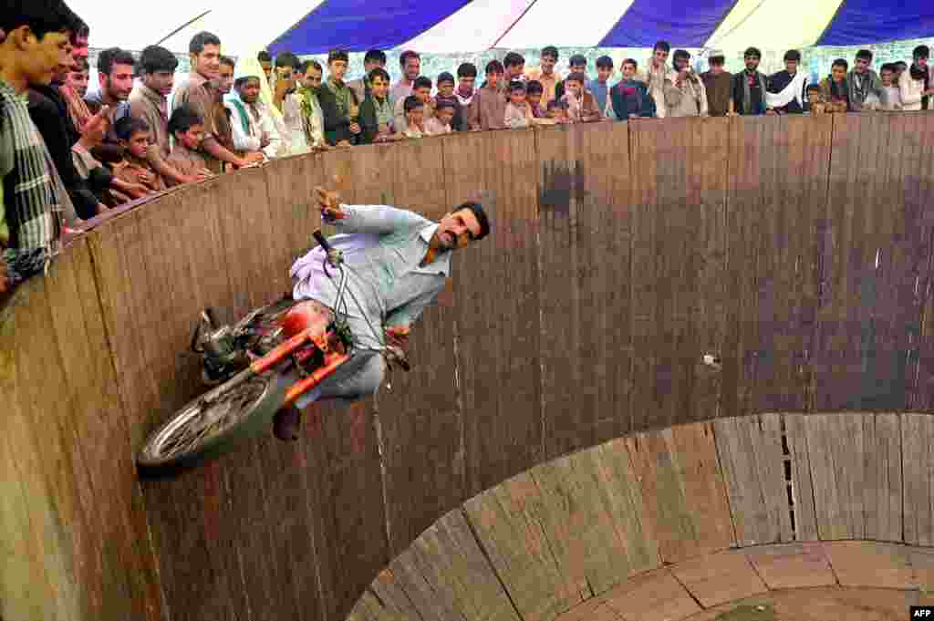 A circus performer rides a motorcycle on the "Wall of Death" at a fair on the second day of Eid al-Fitr in Jalalabad, Afghanistan. (AFP/Noorullah Shirzada)