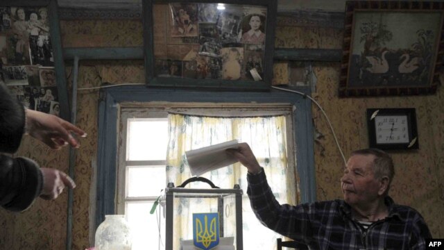 An elderly man casts ballot from home in Orane, near Kyiv, on January 17.
