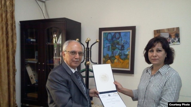 RFI correspondent Faiqa Rasul Srhan receives her certificate of merit from the cultural attaché for the Iraqi Embassy in Jordan.
