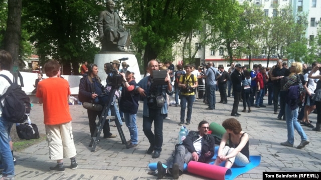 Protesters lie on camping mats in front of the statue of Abai in Moscow.