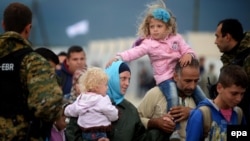Migrants board a train after crossing the border between Macedonia and Greece on September 8.