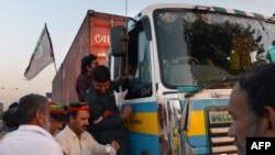 Supporters of Imran Khan's PTI party check the documents of a truck driver at an unofficial checkpoint in a bid to block NATO supply trucks in Peshawar on December 4.