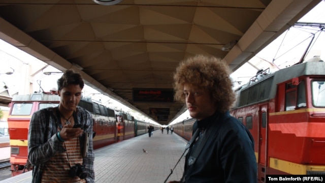 Blogger and activist Ilya Varlamov (right, with camera) working on his civil activism campaign on a Moscow train platform with a fellow activist.