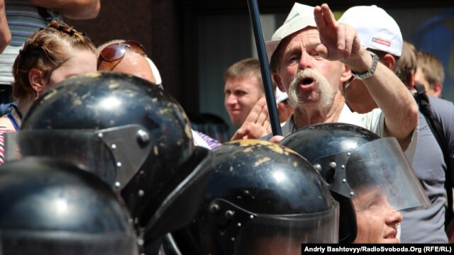 A protester objecting to the Russian-language bill gestures over the heads of riot police in downtown Kyiv on July 5.
