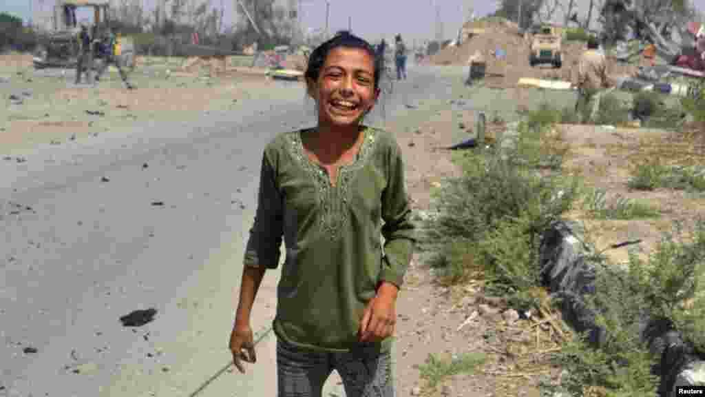 A Syrian girl cheers near the site where a jet fighter belonging to forces loyal to Syria's President Bashar al-Assad crashed in Deir al-Zor. (Reuters/Fayez Suleiman)