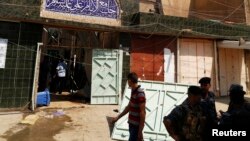 Iraqi security forces stand guard outside a Shi'ite mosque after a suicide bomb attack in the New Baghdad district, eastern Baghdad, on August 25.