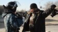Сотрудник полиции проверяет мужчину в городе Жанаозен Мангистауской области. 19 декабря 2011 года. 