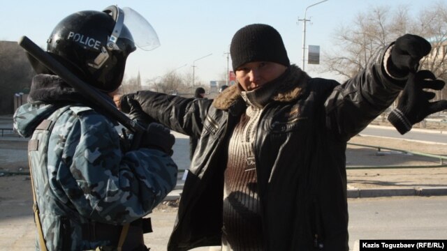 Полицей қала тұрғынын тексеріп тұр. Жаңаөзен, 19 желтоқсан 2011 жыл. (Көрнекі сурет)