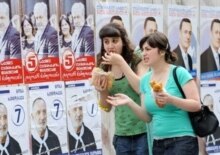 Georgia -- Women pass by campaign posters in Tbilisi, 20May2008