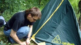 Noskov pitches a tent in the woods in Ukraine's Ternopil region.