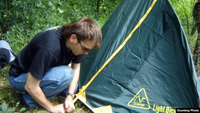 Noskov pitches a tent in the woods in Ukraine's Ternopil region.