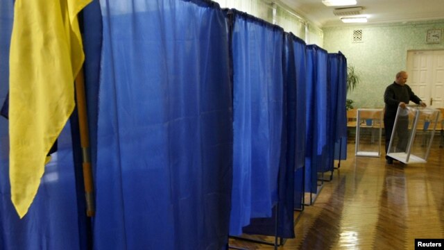 Hoping to do it all again? A member of the local electoral commission carries a ballot box at a polling station in Kyiv on October 27.