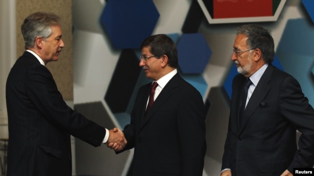 Turkish Foreign Minister Ahmet Davutoglu (center), accompanied by his Afghan counterpart Zalmay Rasul (right), shakes hands with U.S. Deputy Secretary of State William Burns before the Istanbul Conference on November 2.