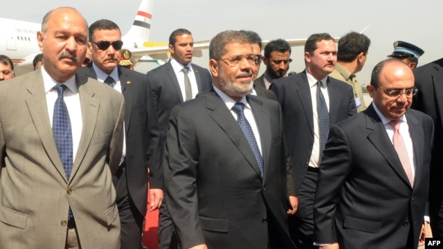 Egyptian President Muhammad Morsi (center) is flanked by Pakistani and Egyptian officials upon his arrival at the Chaklala military air base in Rawalpindi on March 18. 