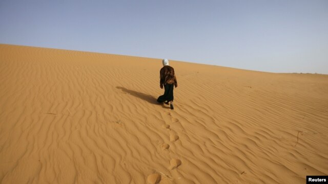 Сахара шөлінде кетіп бара жатқан әйел. Алжир, 24 наурыз 2008 жыл. (Көрнекі сурет)