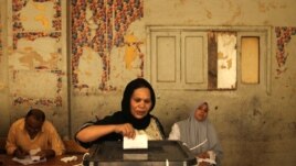 An Egyptian Christian Coptic woman casts her vote in the country's presidential election at a polling station in Cairo. 