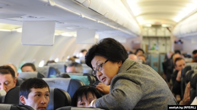 Her spokesman says Otunbaeva (standing) could often be seen on commercial flights mingling with the other passengers.