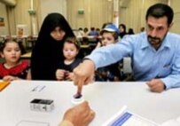 An Iraqi man prepares to vote in Australia today as his family looks on