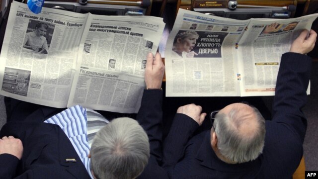 Ukrainian parliament deputies catching up on the news.